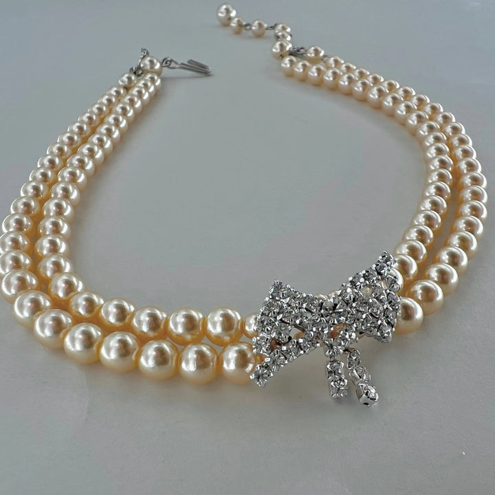 Halskæde, choker med beige voksperler og sløjfe vedhæng, forsølvet messing Beadhouse of Copenhagen